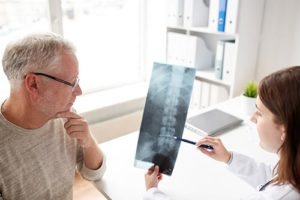 a doctor explaining to a patient how surgery will go with anesthesia for spine and interventional radiology